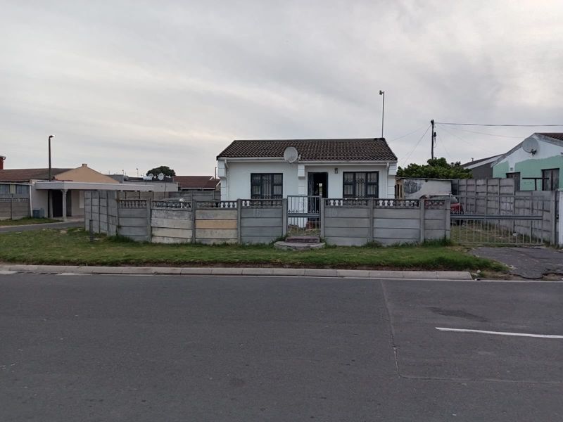 Front elevation of a detached house featuring a precast concrete boundary wall, security gates, and tiled roof, situated on a residential street.