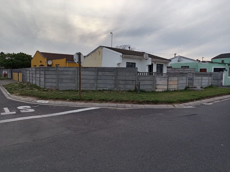 Street view of a residential property featuring a precast concrete boundary wall and tiled roof, showing signs of exterior wear and maintenance needs.