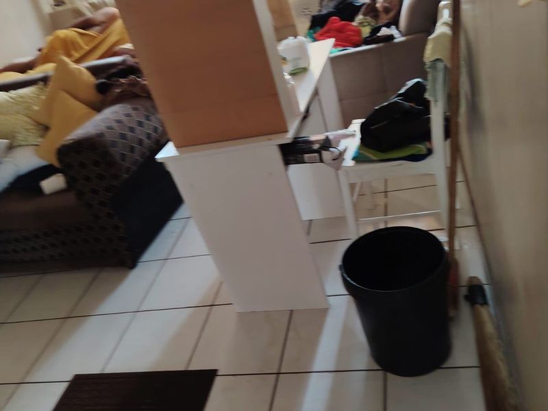 A living area featuring ceramic floor tiles with visible damage, requiring maintenance and potential flooring repairs to improve the space.