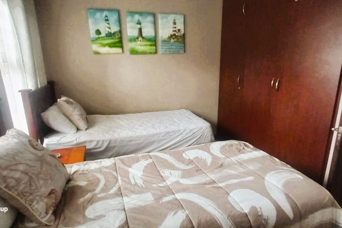 A bedroom featuring built-in wooden cupboards and tiled flooring, providing functional storage and a neutral living space.