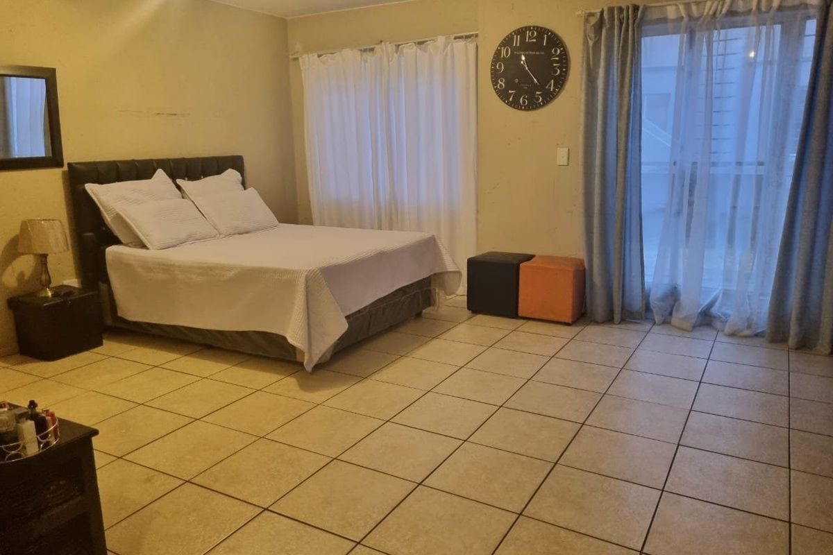 Spacious bedroom featuring tiled flooring and a sliding glass door providing access to an outdoor area.