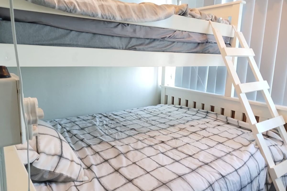 A bedroom featuring vertical blinds and a built-in bunk bed structure.