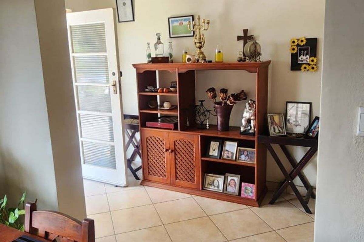 A view through a wide doorway into an adjacent living area featuring neutral wall tones and ceramic floor tiles.