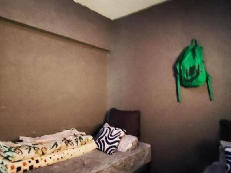 A small bedroom featuring dark painted walls and a basic layout, requiring cosmetic updates to improve the overall aesthetic and finish.