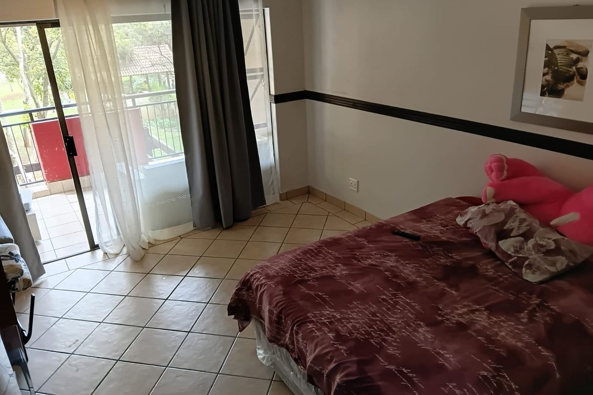 Bedroom featuring tiled flooring and a sliding glass door providing direct access to a private balcony.