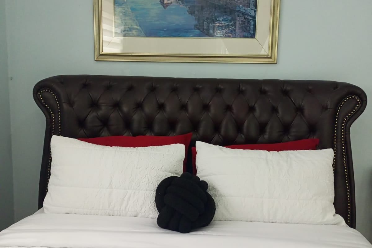 A bedroom featuring a tufted leather headboard.