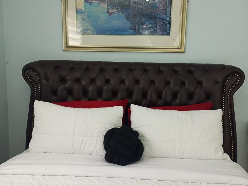 A bedroom featuring a tufted leather headboard.