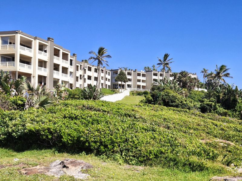 Exterior view of a multi-story apartment complex featuring private balconies and well-maintained landscaped grounds.