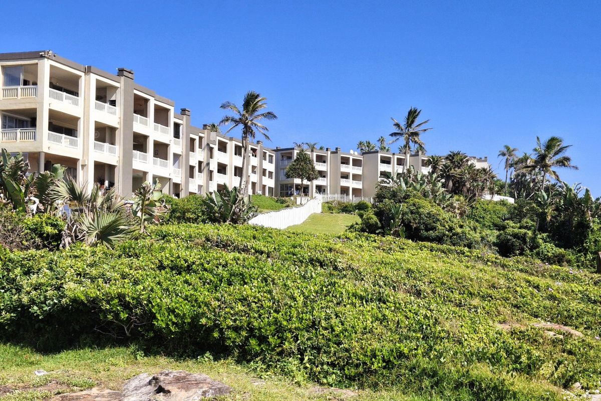 Exterior view of a multi-story apartment complex featuring private balconies and well-maintained landscaped grounds.