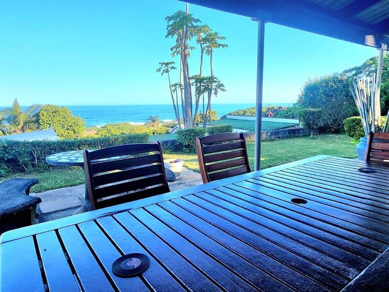 A covered outdoor patio area featuring paved flooring and a scenic ocean view, providing a pleasant space for outdoor relaxation.