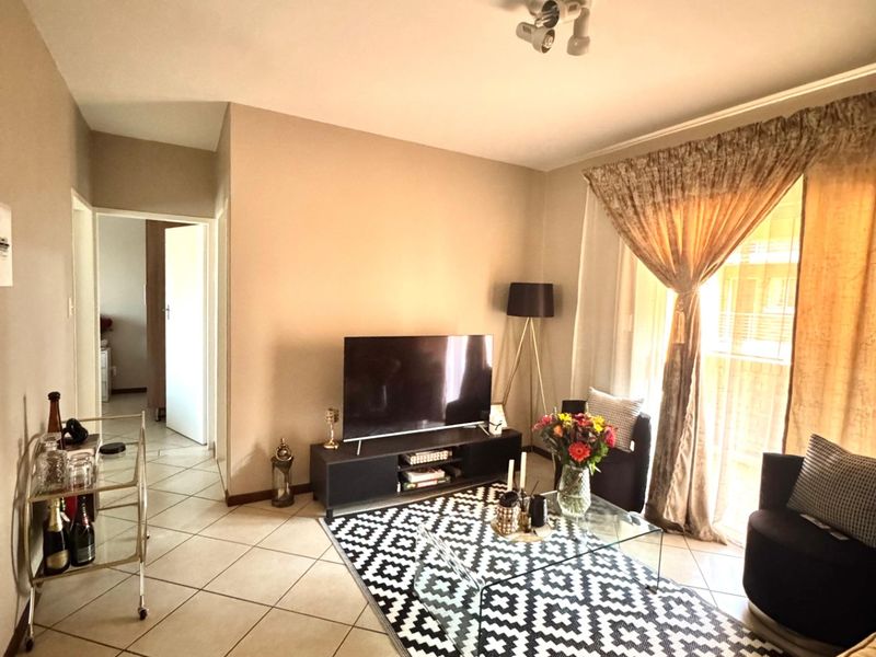 A comfortable living room featuring tiled flooring and a sliding glass door providing access to an outdoor area.