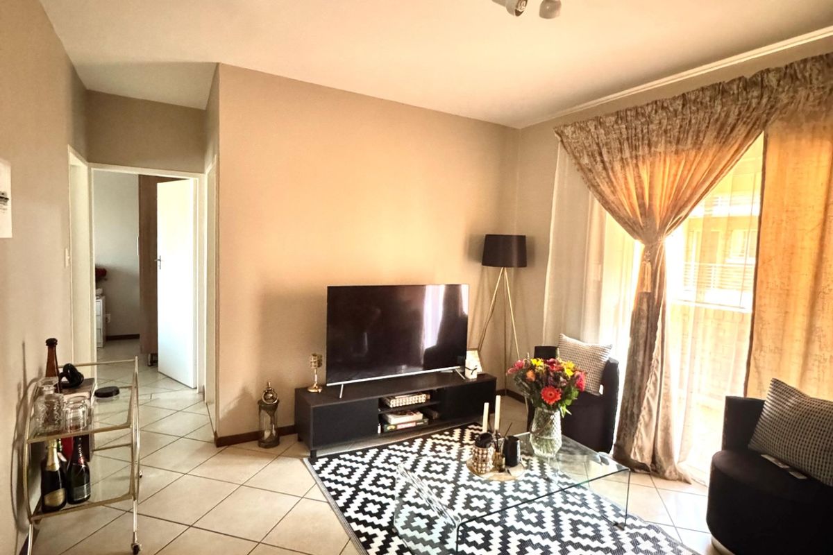 A comfortable living room featuring tiled flooring and a sliding glass door providing access to an outdoor area.