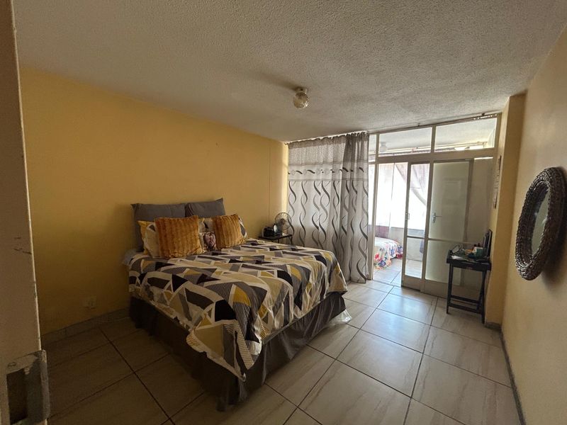 Bedroom featuring tiled flooring and a sliding glass door providing access to an adjoining balcony area.