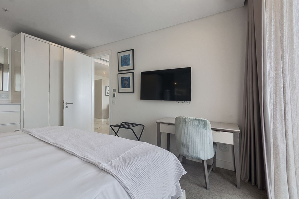 A well-maintained bedroom featuring built-in wardrobes, neutral finishes, and recessed lighting, offering a clean and functional living space.