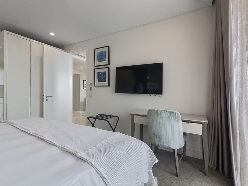 A well-maintained bedroom featuring built-in wardrobes, neutral finishes, and recessed lighting, offering a clean and functional living space.