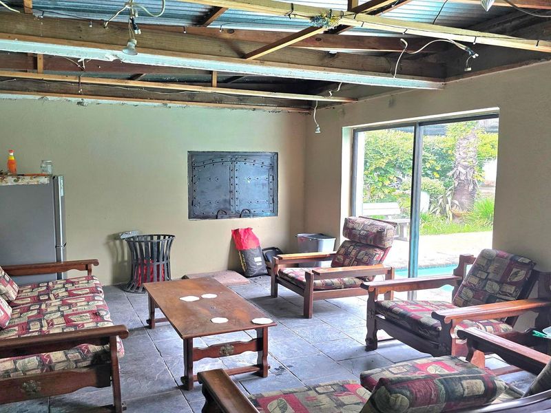 Covered patio area featuring tiled flooring, a built-in wall safe, and direct access to the garden through sliding glass doors.