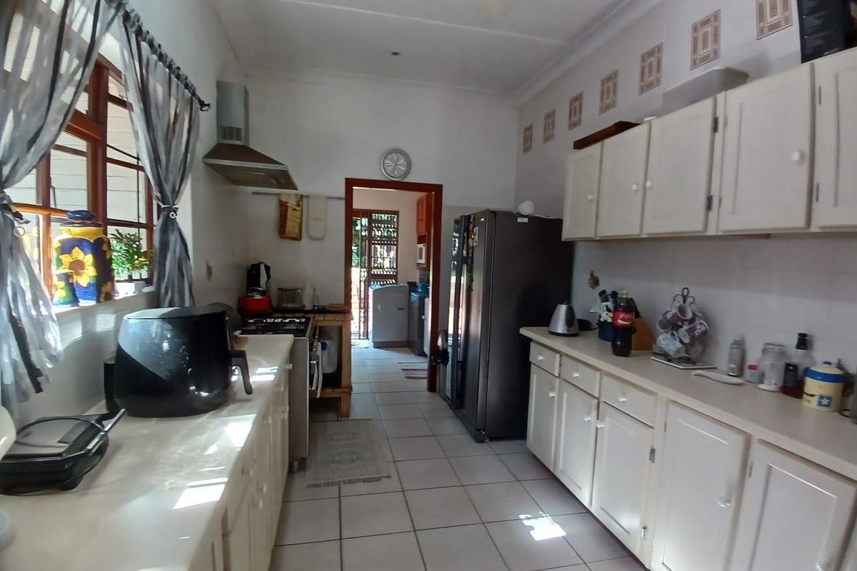 A functional kitchen featuring white cabinetry, tiled flooring, and a gas stove, with a direct view into the adjacent laundry or utility area.