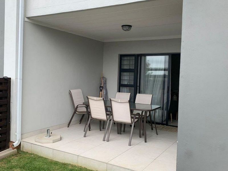 A covered patio area featuring tiled flooring and direct access to the interior through a sliding glass door.