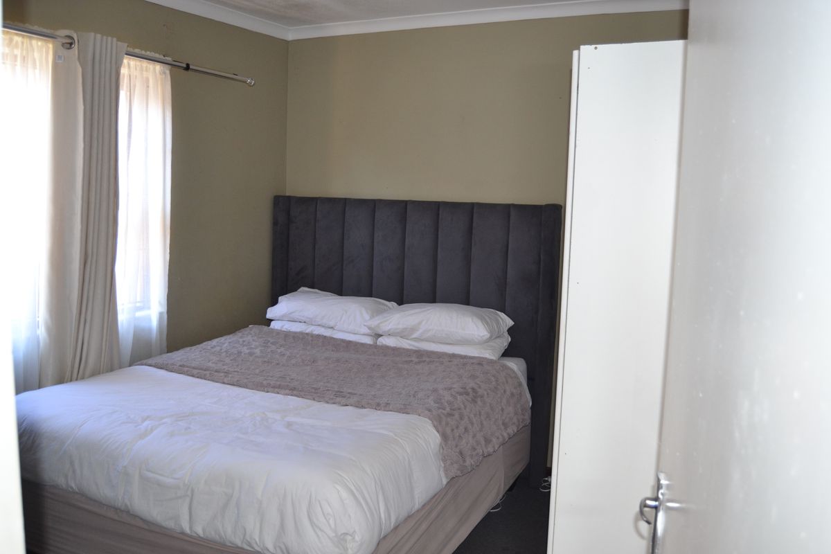 A standard bedroom featuring neutral wall tones and a built-in wardrobe, offering a functional space for rest.
