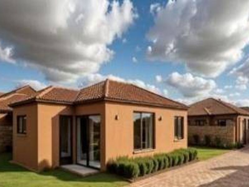 A well-maintained single-story residential property featuring a terracotta tiled roof, stucco exterior, and a paved driveway with landscaped garden borders.