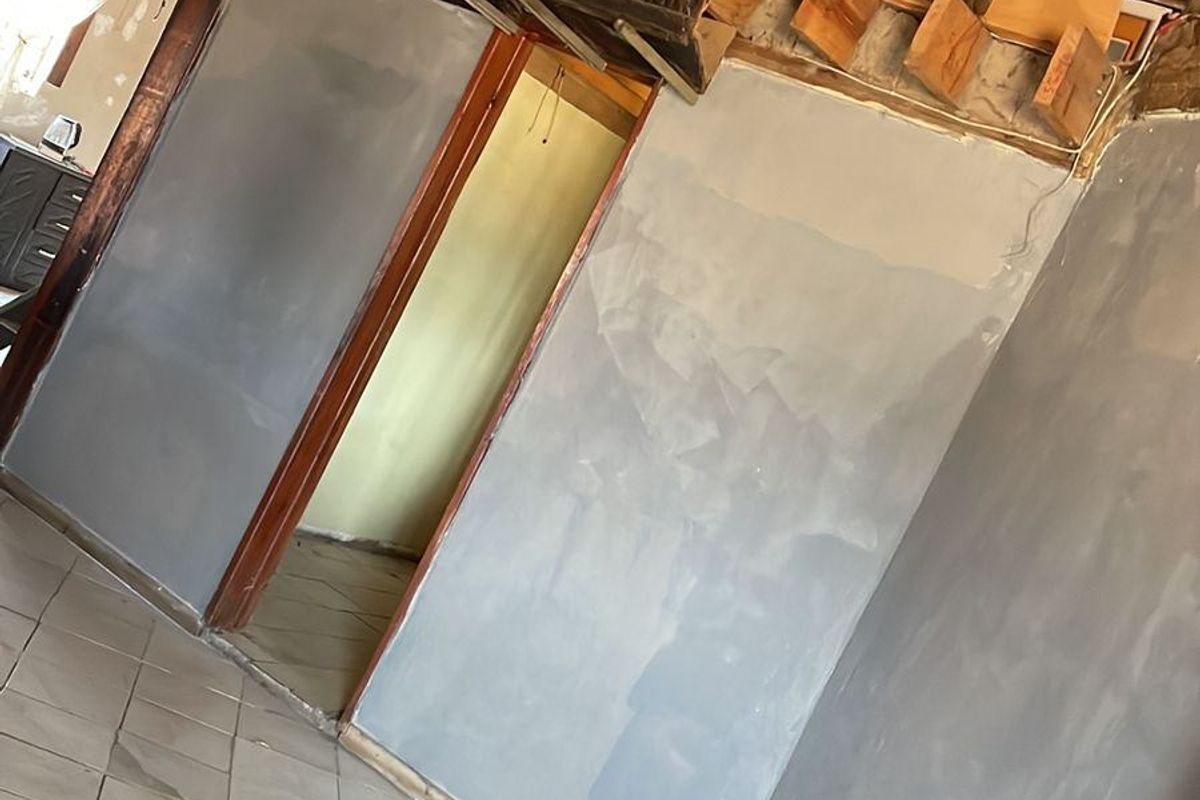 Interior space featuring a traditional thatched roof with exposed timber rafters, ceramic tiled flooring, and unfinished wall surfaces currently undergoing renovation.