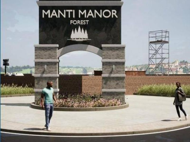 A modern stone masonry entrance archway featuring the Manti Manor Forest signage, set within a landscaped residential estate entrance.