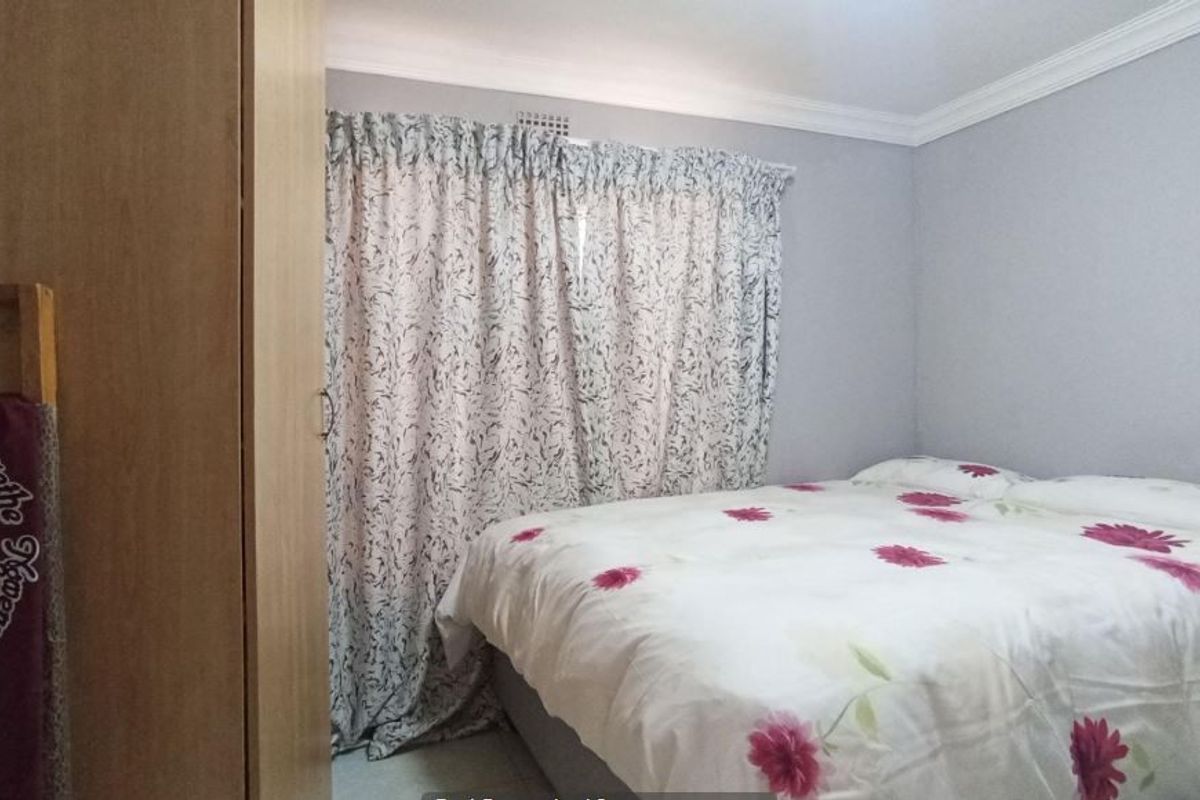A functional bedroom featuring a built-in wardrobe and decorative ceiling cornicing, providing a neutral base for personal styling.