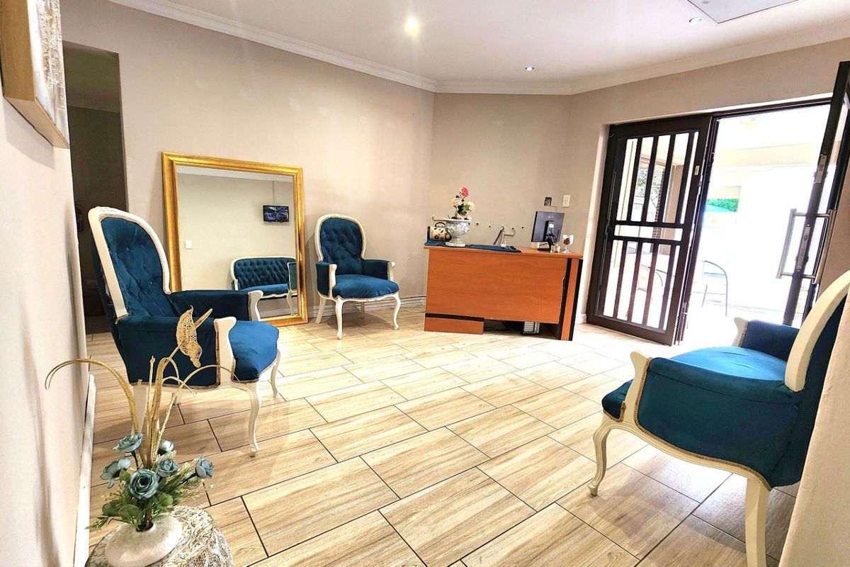 A bright and welcoming commercial reception area featuring tiled flooring, recessed downlighting, and a secure entrance door.
