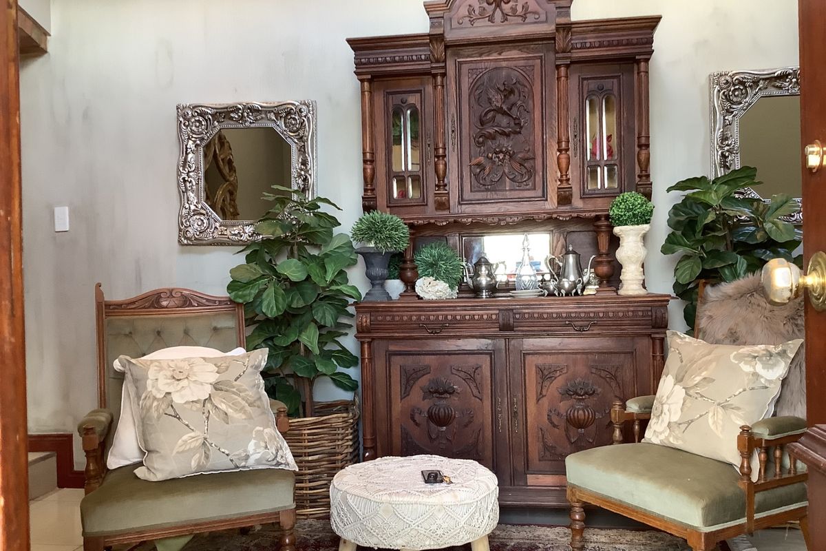 A cozy living area featuring a classic wooden hutch and decorative wall mirrors, creating a traditional and inviting atmosphere.