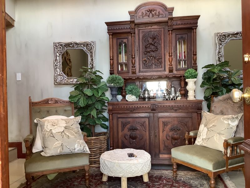 A cozy living area featuring a classic wooden hutch and decorative wall mirrors, creating a traditional and inviting atmosphere.