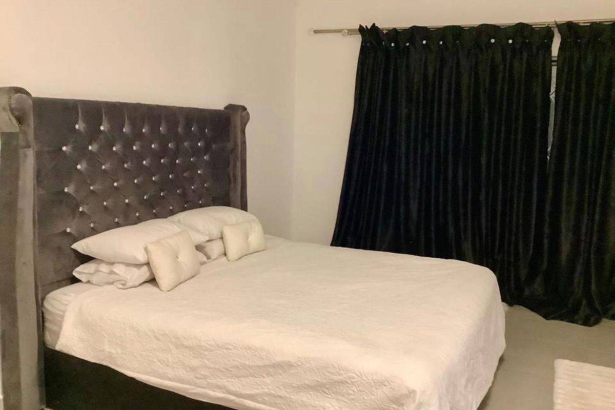 A bedroom featuring neutral walls and dark curtains, providing a blank canvas for potential interior design updates.