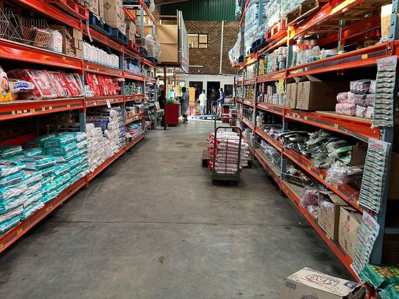Industrial warehouse space featuring high-capacity steel racking systems, concrete flooring, and exposed roof trusses, suitable for storage or distribution operations.