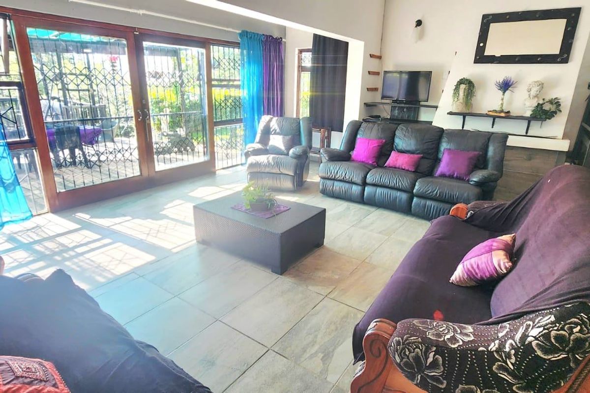 Spacious living room featuring large sliding glass doors with security gates, providing ample natural light and direct access to the outdoor area.