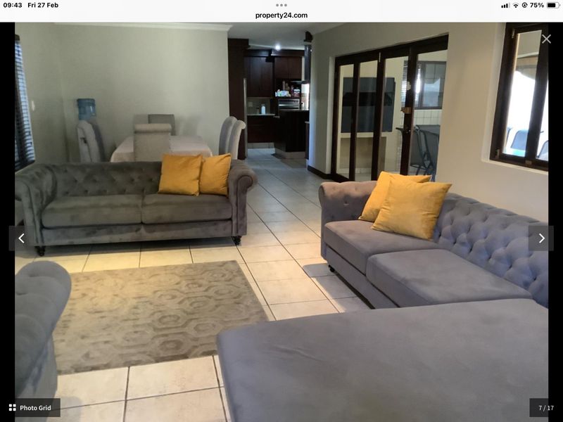 Spacious open-plan living and dining area featuring tiled flooring and direct access to an adjacent patio through sliding glass doors.