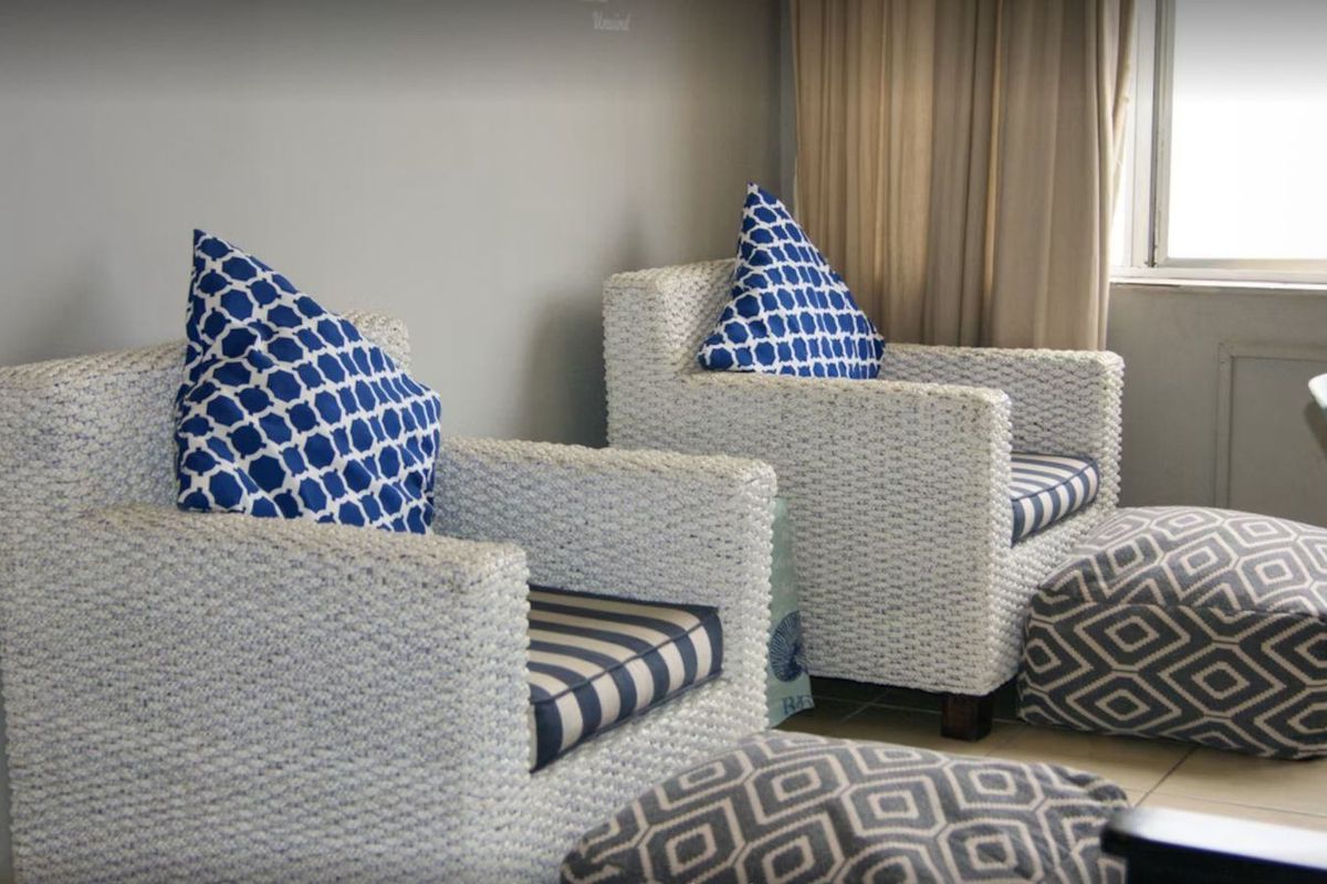 A living area featuring tiled flooring and neutral wall finishes, providing a functional space for relaxation.