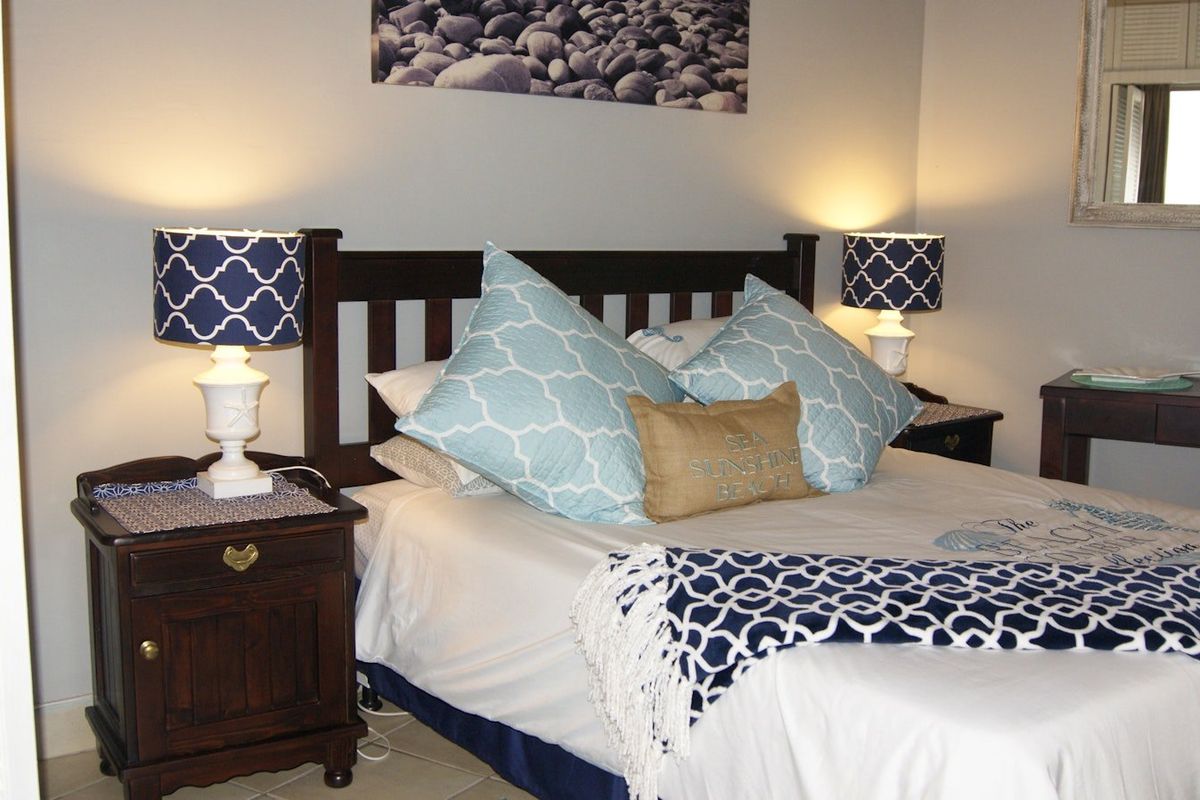 A well-lit bedroom featuring neutral wall tones and tiled flooring, providing a comfortable and functional sleeping space.