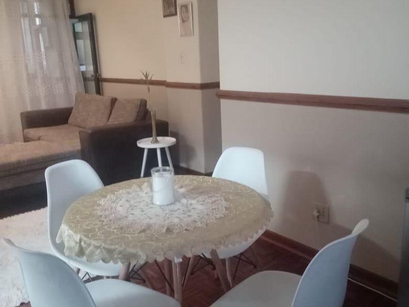 A dining area featuring parquet flooring and decorative chair rail molding, providing a functional space for meals.