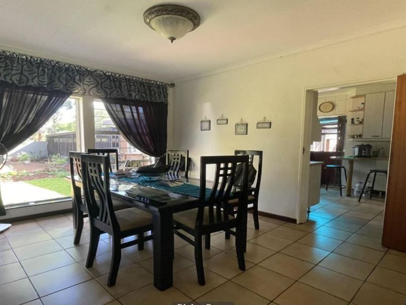 A dining room featuring ceramic floor tiles and a view through to the kitchen area.