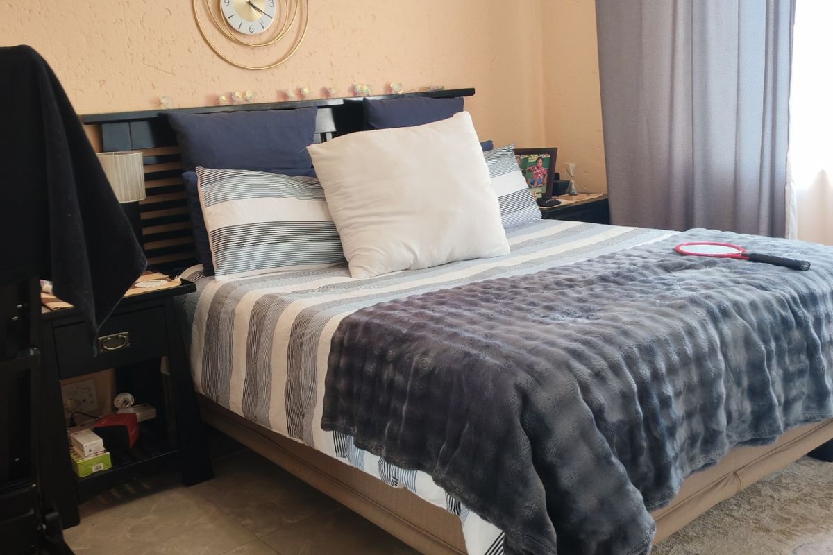 A bedroom featuring tiled flooring and neutral wall finishes, providing a functional space with natural light from the window.