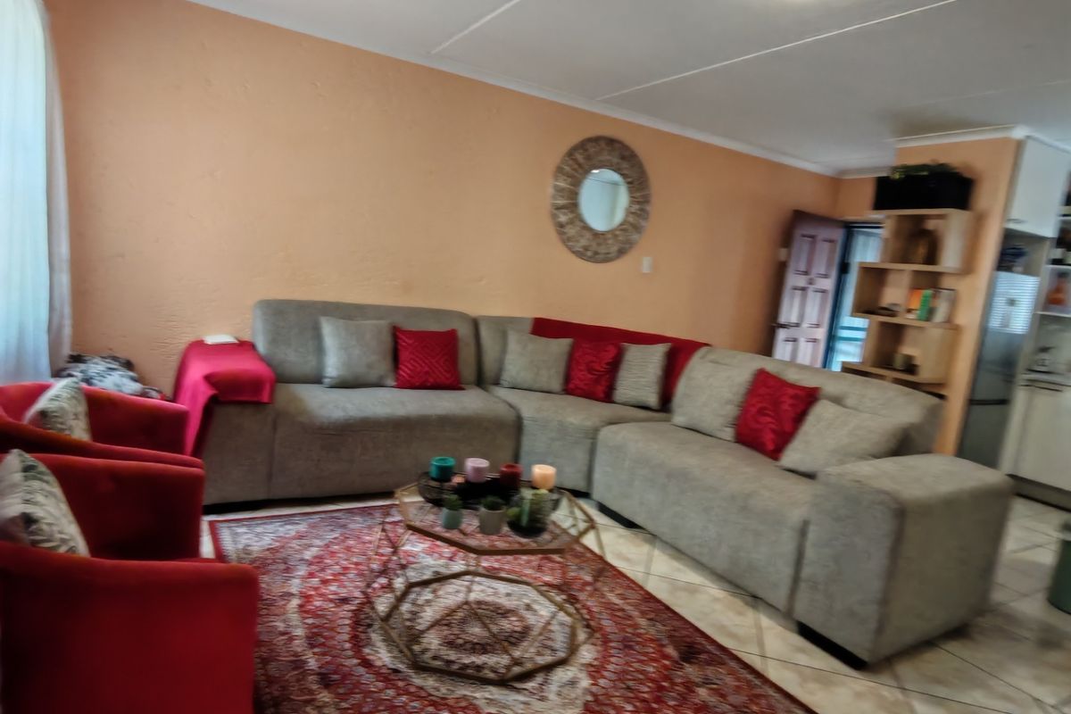 A living room area featuring tiled flooring and neutral wall finishes, providing a functional space for relaxation.