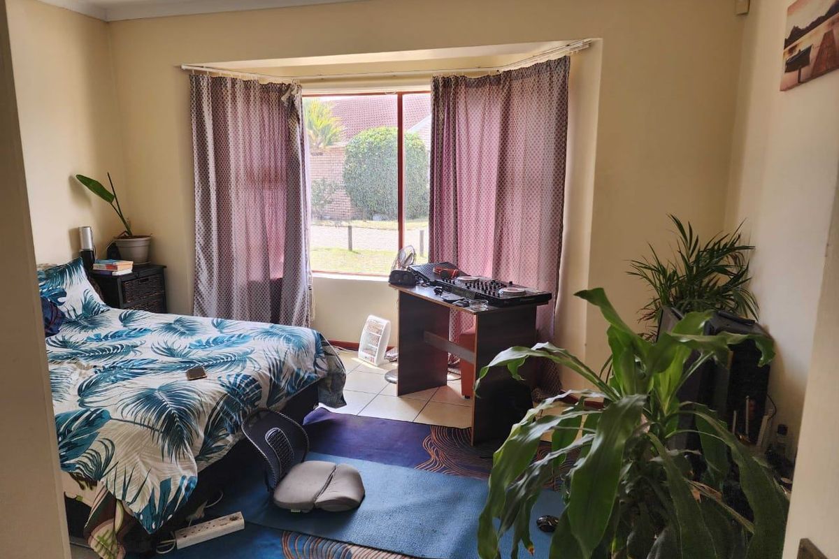 A bedroom featuring a bay window and tiled flooring, offering a functional space with natural light.