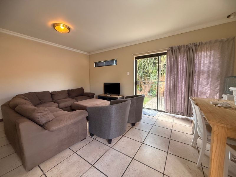 Open plan living and dining area featuring tiled flooring and a sliding glass door providing access to the outdoor space.