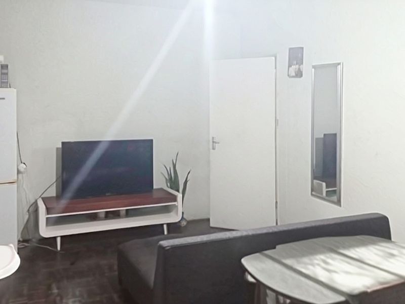 A simple living area featuring neutral walls and a standard internal door, providing a functional space for relaxation.
