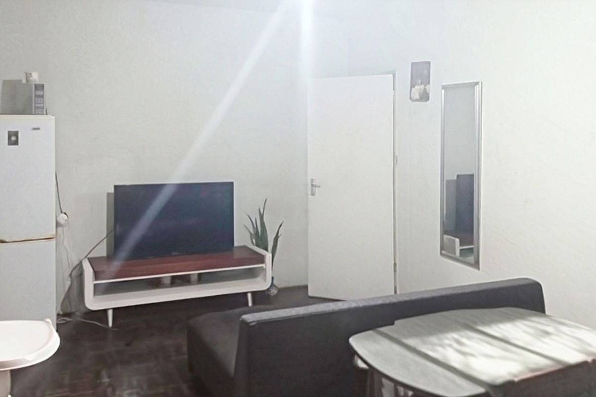 A simple living area featuring neutral walls and a standard internal door, providing a functional space for relaxation.