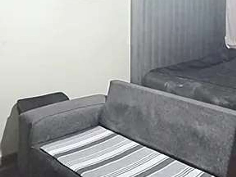 A bedroom featuring a built-in headboard, presented in a lived-in condition.