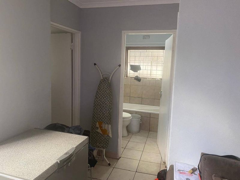 A functional hallway area providing access to adjacent rooms, featuring tiled flooring and neutral wall finishes.