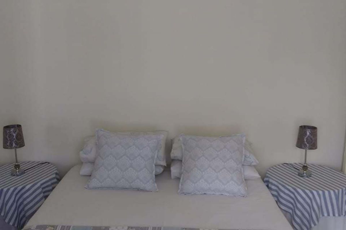 A simple bedroom interior featuring a double bed with bedside tables.
