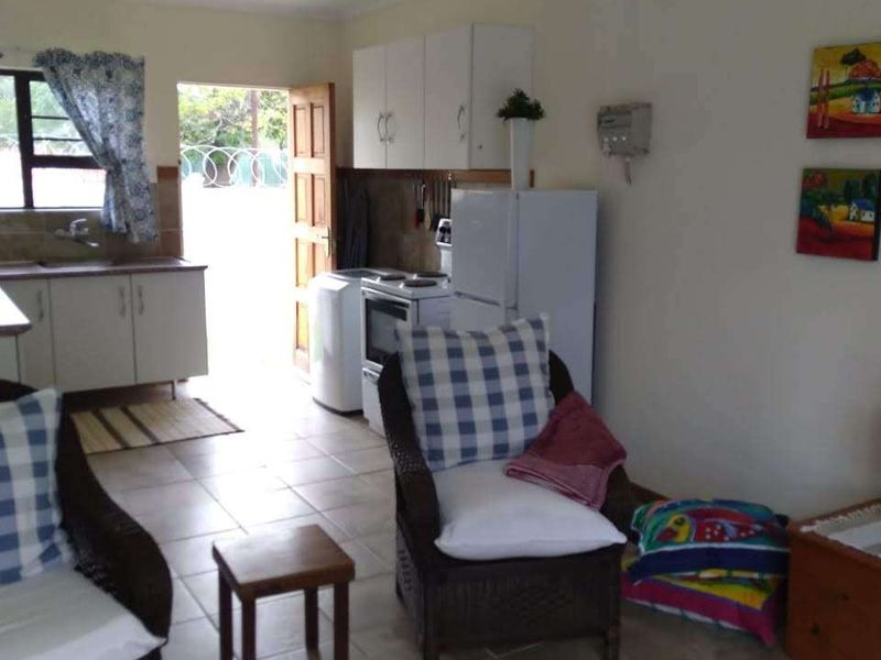 Open plan living and kitchen area featuring tiled flooring, functional cabinetry, and direct access to the exterior.