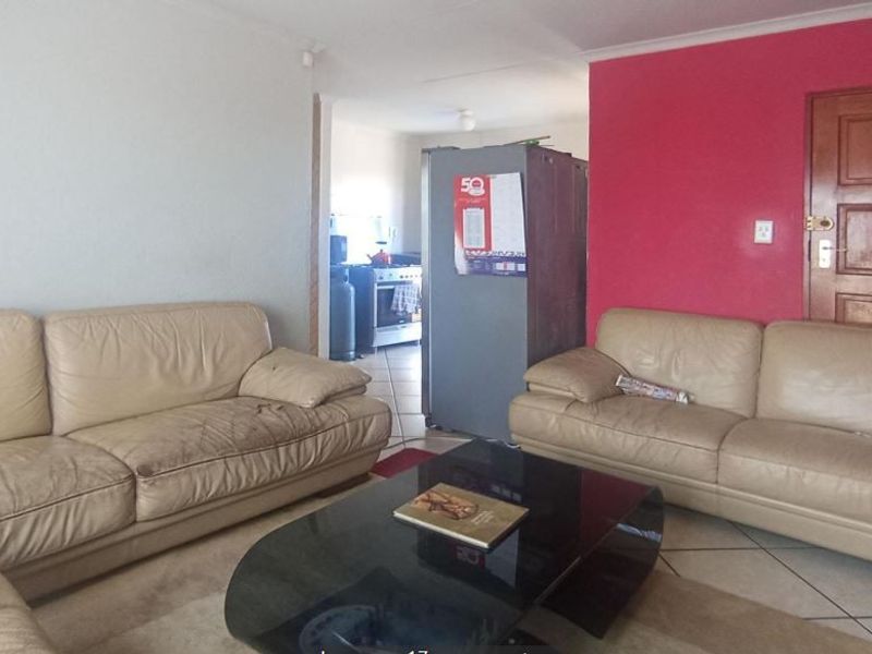 Open plan living area featuring tiled flooring and direct access to the kitchen space.