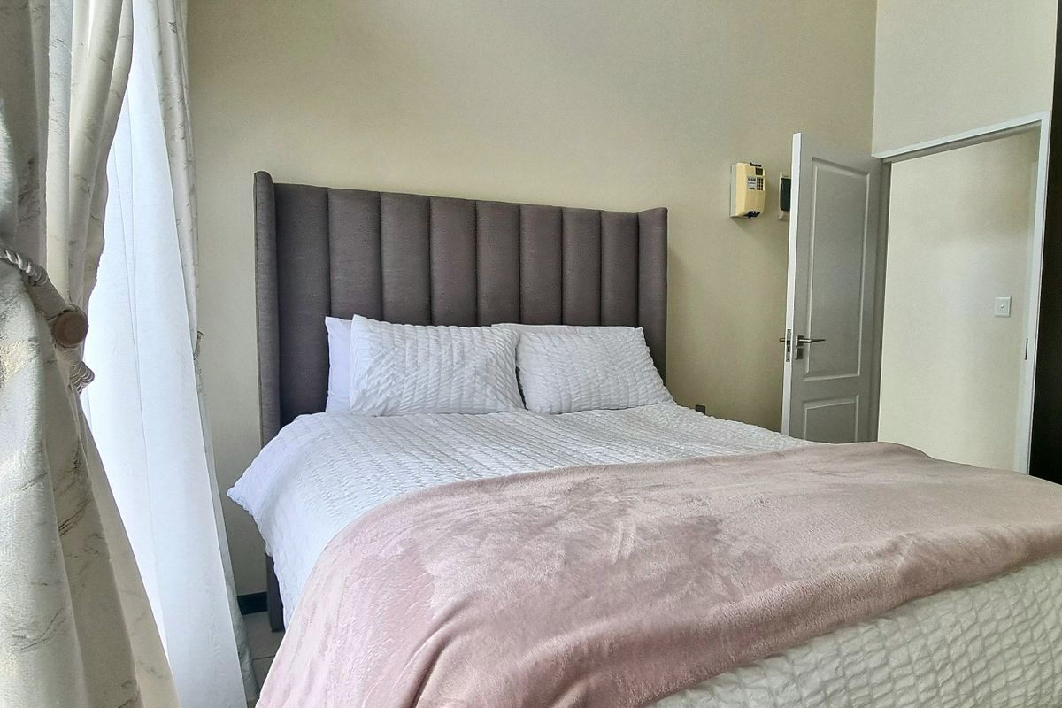A well-maintained bedroom featuring built-in dark wood cabinetry and neutral wall finishes, providing a clean and functional living space.